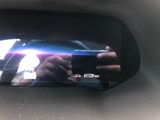 a person taking a picture of themselves in the rear view mirror of a car