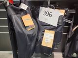 trois vestes suspendues à un portant dans un magasin