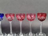 four wine glasses are lined up in a row on a table