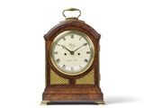 une petite horloge en bois avec des chiffres romains sur le cadran