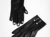 a pair of black leather gloves sitting on top of a white table