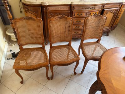 several chairs and a table in a room next to a dresser