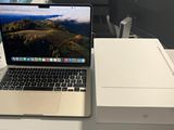 un ordinateur portable posé sur un bureau, à côté d'une boîte