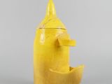 an image of a yellow vase with a face made out of a banana
