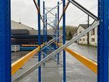 a blue and yellow metal rack with a yellow handle