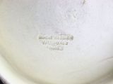 a close up of a white bowl with a brown lid