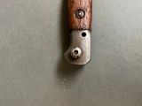 a knife with a wooden handle hanging on a wall