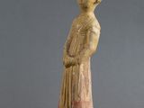 une vieille statue représentant une femme avec un oiseau sur l'épaule