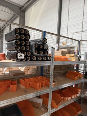 many orange bins on the shelves in the warehouse