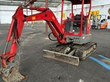 une pelleteuse rouge garée dans un grand entrepôt