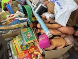 un tas de jouets dans une boîte en carton posée par terre