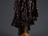 a dress on a mannequin stand with flowers on it