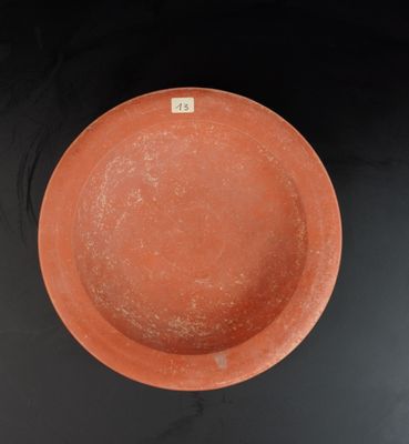 un bol orange posé sur une table noire