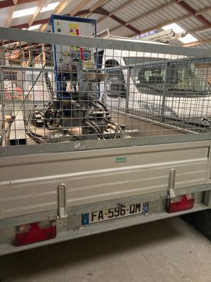 un camion équipé d'une cage à l'arrière, à l'intérieur d'un bâtiment
