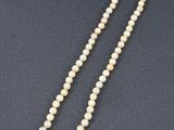 un collier de perles blanches avec un fermoir en or