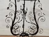 an image of a wrought iron plant stand with a bird on it