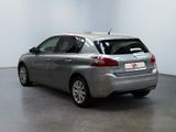 the back of a silver car is parked in a white room