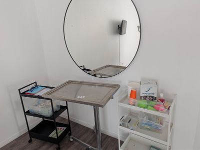 a small table with a mirror on it in the corner of a room