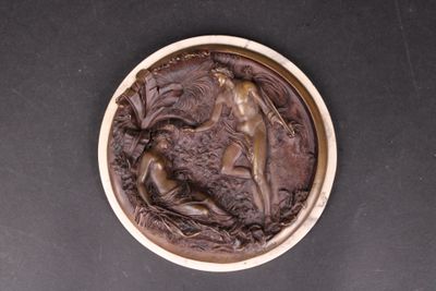 a bronze plaque depicting a woman and a goat
