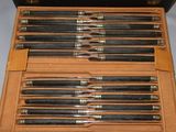 six pens in a case that are sitting on a table
