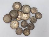 a pile of old coins sitting on top of a white surface