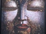 une peinture à l'huile représentant un visage de Bouddha recouvert de feuilles d'or