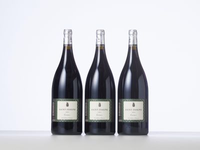 trois bouteilles de vin posées sur une table l'une à côté de l'autre