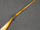 an old rifle with a wooden handle on a gray surface