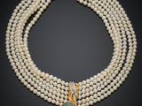 un collier de perles à trois rangs orné d'une pierre bleue et d'un fermoir en or