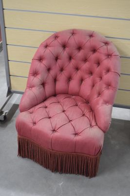 une chaise rose ornée de franges dans une pièce