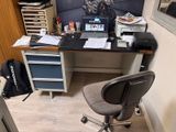 a computer desk with a laptop on it in a small room
