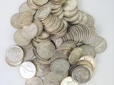 a pile of silver coins on a white surface