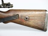 an old wooden rifle with a black handle on a white surface