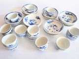 beaucoup de tasses et soucoupes bleues et blanches posées sur une table