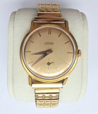 montre-bracelet exposée, avec un bracelet en tissu blanc et en métal doré