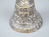 a silver bell with a gold design on it