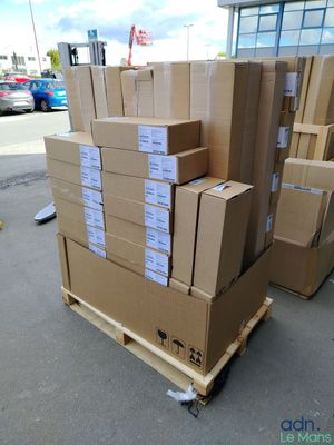 des cartons empilés sur une palette devant un bâtiment