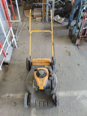 a yellow lawn mower that is sitting in a garage