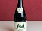une bouteille de vin posée sur une table à côté de deux bouteilles de vin