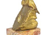 a gold statue of a bird on a marble base