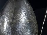 a close up of a metal helmet with a chain attached to it