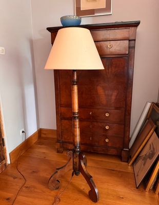 a lamp that is on a tripod stand in a room