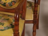 two wooden chairs with a yellow and green floral upholstered back
