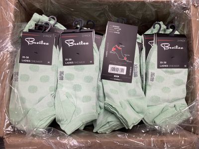 Plusieurs paires de chaussettes vertes se trouvent dans une boîte posée sur une table