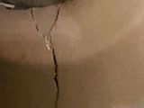 a close up of a toilet with a hole in the wall