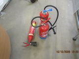 a fire extinguisor sitting on the floor next to a cat