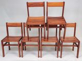 six chaises en bois alignées les unes à côté des autres sur un fond blanc