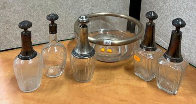 Des bouteilles et des verres sont posés sur une table, à côté d'un seau à glace en verre.