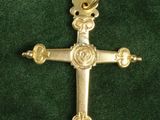 a close up of a gold cross on a green cloth