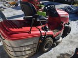 a red lawn mower parked in a parking lot